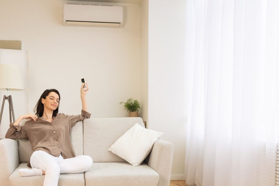 chica en su hogar con mando de aire acondicionado